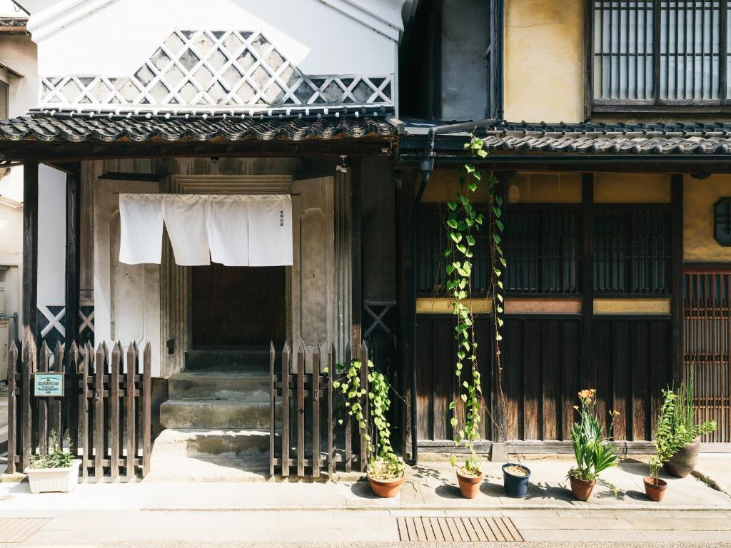 un vecchio edificio con piante in vaso di fronte ad esso di RITA Izumo Hirata a Izumo