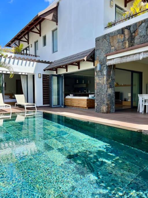 a swimming pool in front of a house at Luxury Villa - 2 minutes walk from the beach in Grand Baie