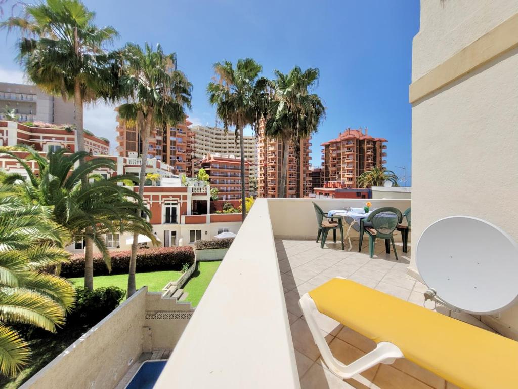 balkon z żółtą ławką i palmami w obiekcie California Sweet Home w Puerto de la Cruz