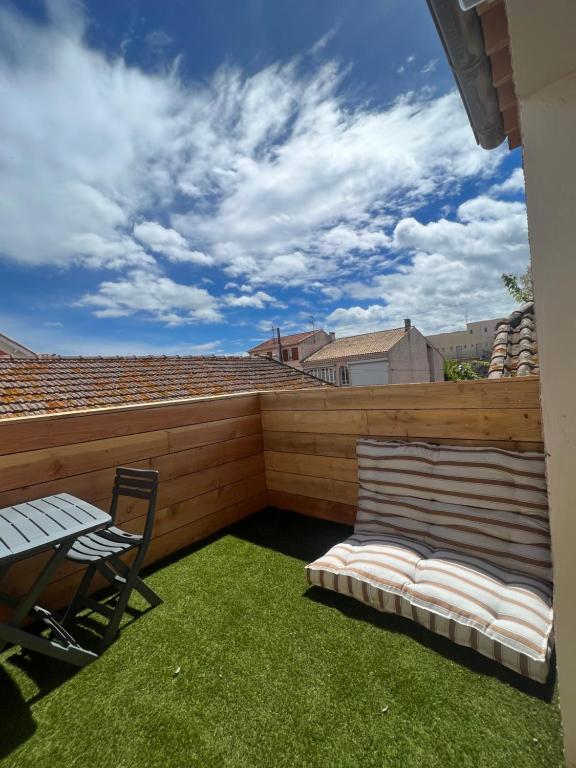 d'un balcon avec une table, une chaise et un banc. dans l'établissement Appartement Grau d'Agde Enjoy et Farniente, au Grau-dʼAgde