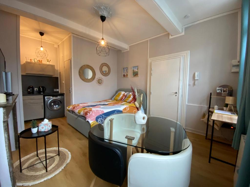 Cette petite chambre comprend un lit et une table en verre. dans l'établissement Studio en plein cœur de ville, à Saint-Omer