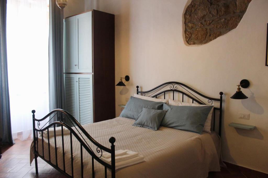 a bedroom with a bed with blue pillows at Il Girasole Storico in Pitigliano