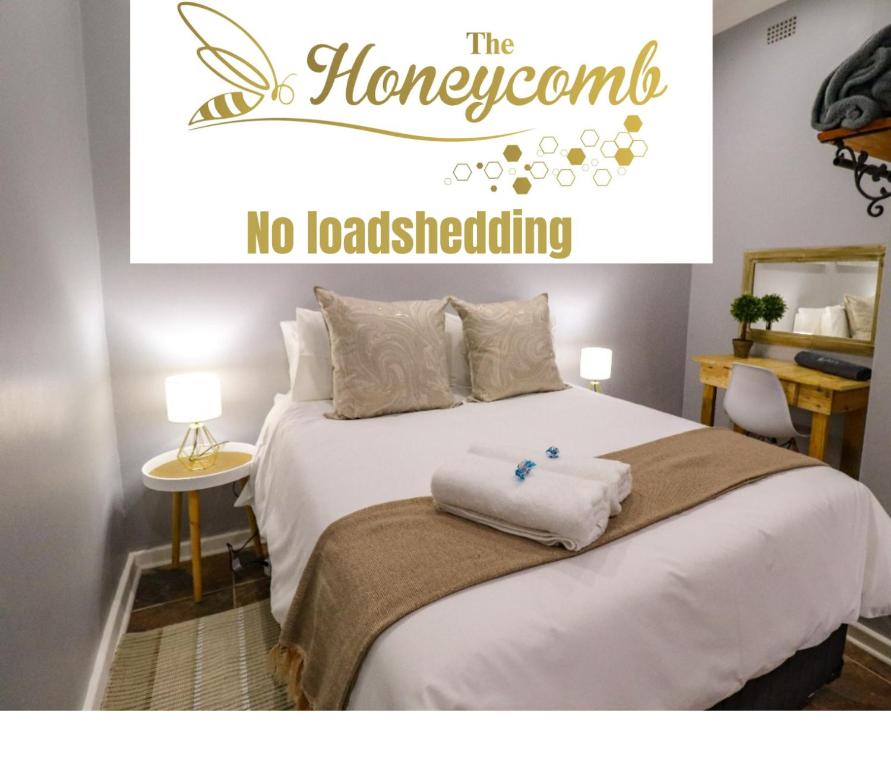 a sign that says the honeycomb no load shedding on a bed at The Honeycomb 2 in Kimberley
