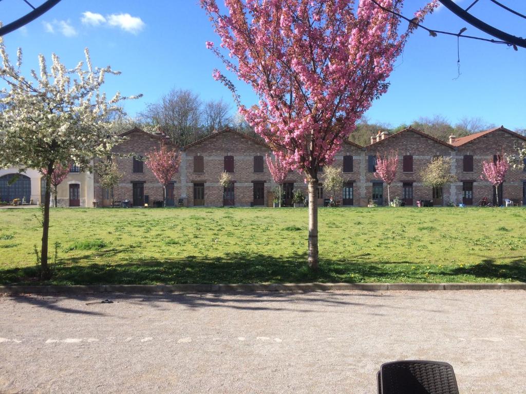 a building with trees in front of a field at Maison mitoyenne mansardé in Saint-Denis