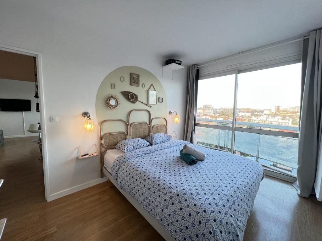 ein Schlafzimmer mit einem großen Bett und einem großen Fenster in der Unterkunft Le Brooklyn - T2 à Compans avec vue remarquable in Toulouse