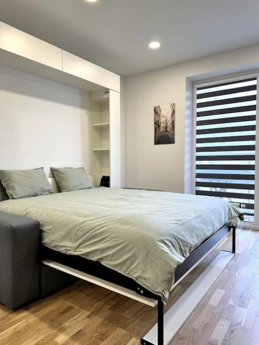 a bedroom with a large bed and a window at Wolfie Apartment, City Center in Vilnius