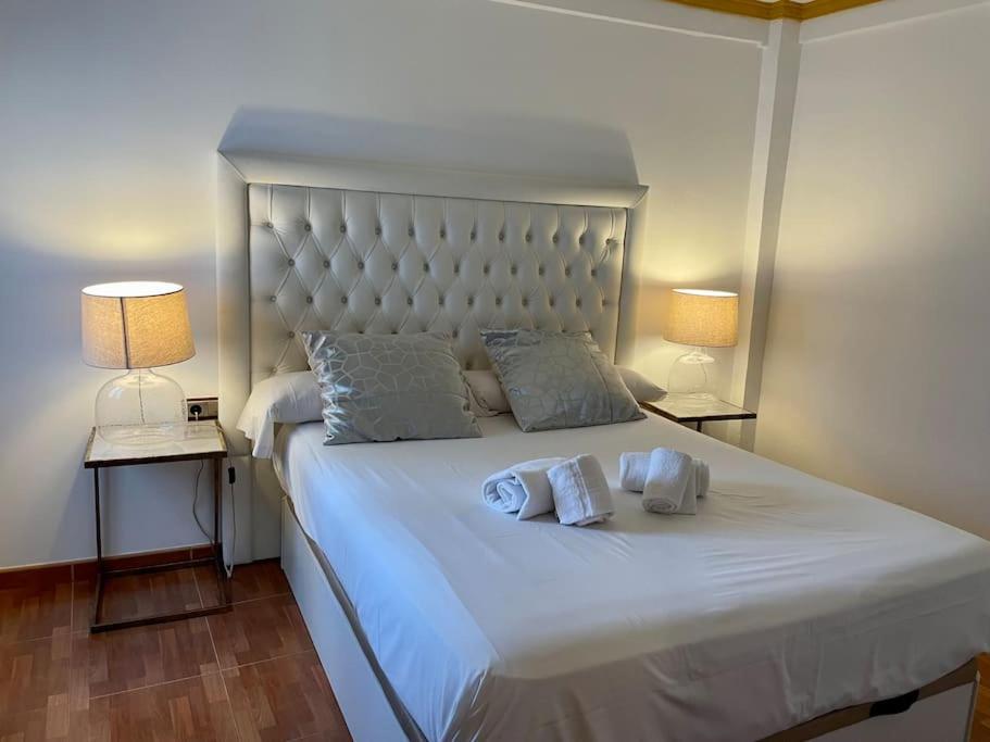 um quarto com uma grande cama branca e 2 almofadas em El Rincón de la Mezquita 1 em Córdoba