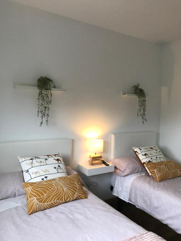 PolancoApartamentos Olga Cantabria的一间设有两张床和台灯的房间