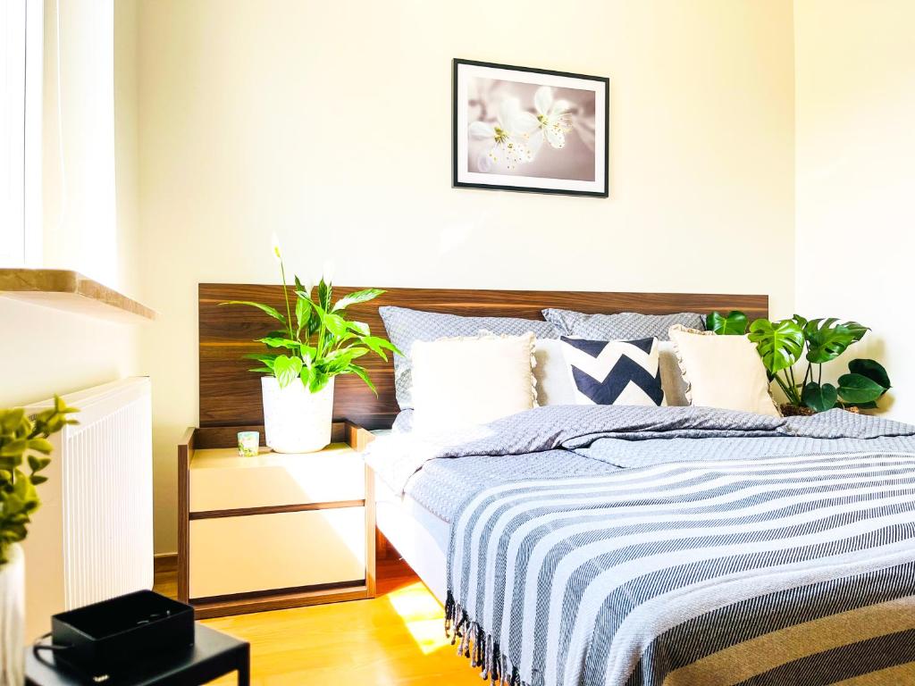 a bedroom with a bed with plants on it at Aquamarina Międzyzdroje Apartament 234 in Międzyzdroje