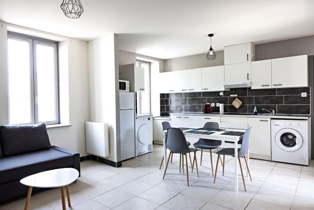 a kitchen and living room with a table and chairs at Le Petit Tyard in Chalon-sur-Saône