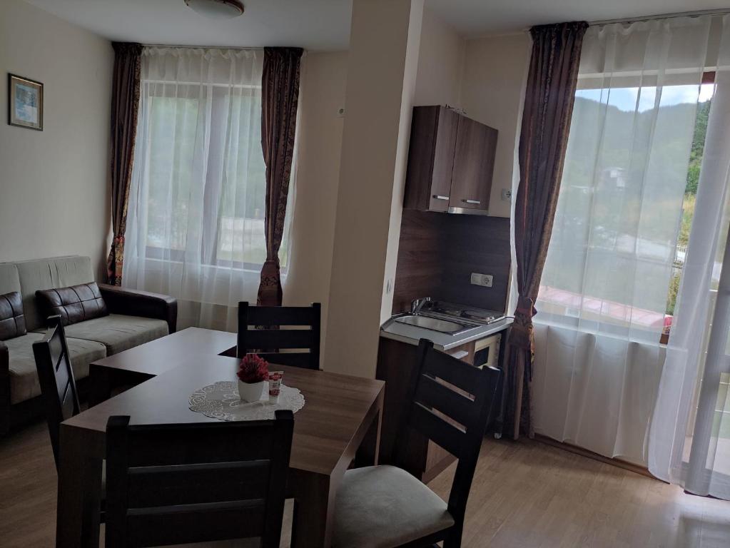 sala de estar con mesa de comedor y cocina en Чепеларе - Пампорово апартамент на 50м от лифт Мечи Чал, en Chepelare
