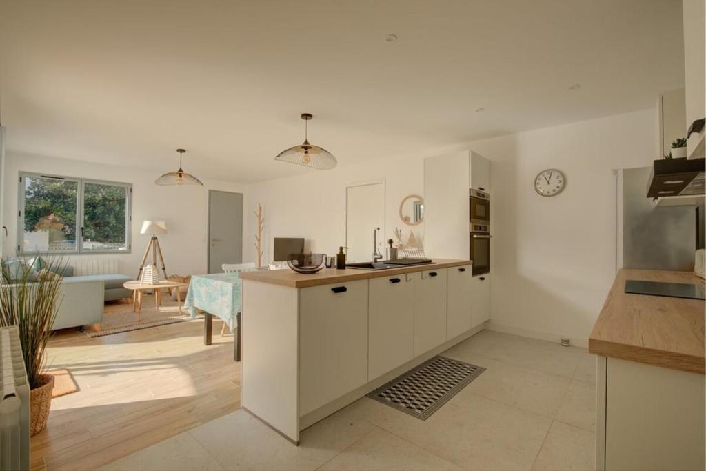 uma cozinha com armários brancos e uma sala de estar em Villa de l'Aiguillon em Arcachon