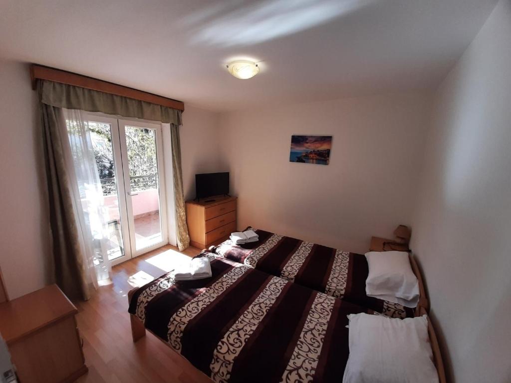 ブドヴァにあるApartments Stanivukovicの大きなベッドと窓のある寝室