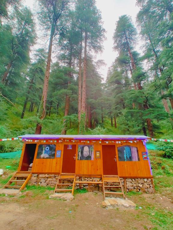 a cabin in the middle of a forest at Shanti People Huts & Camp in Kasol