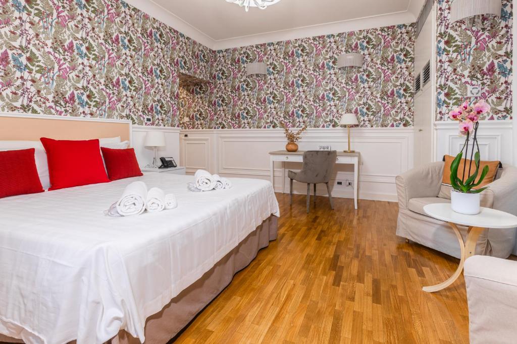 a bedroom with a large white bed with red pillows at Mangili Garden Hotel in Rome