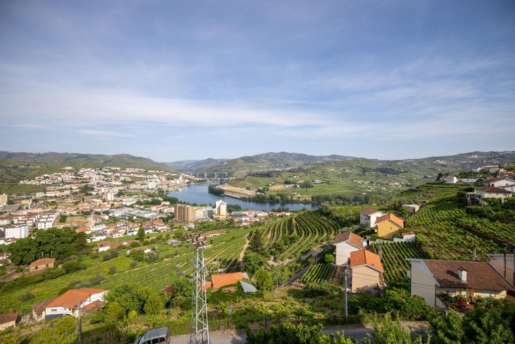 uitzicht op een stad met een rivier en een stad bij Lino's Family in Peso da Régua