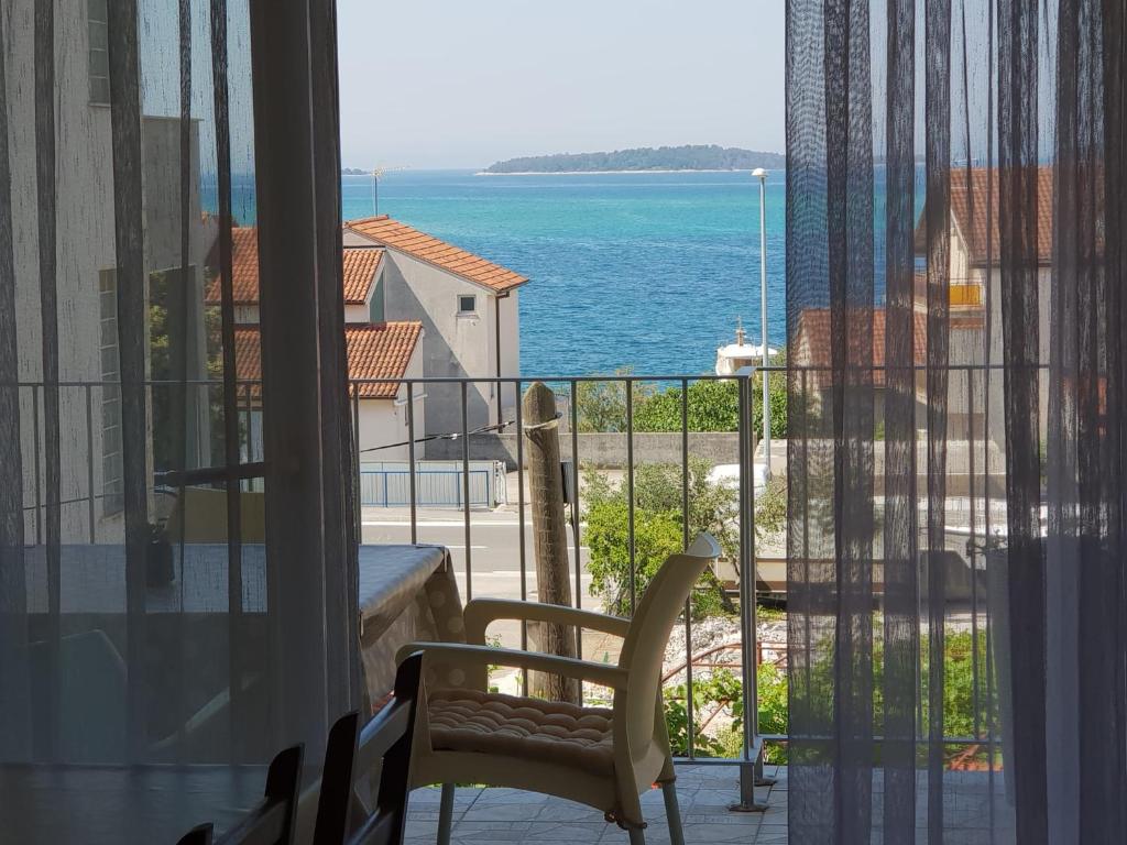 a room with a view of the ocean from a balcony at Princess in Brodarica