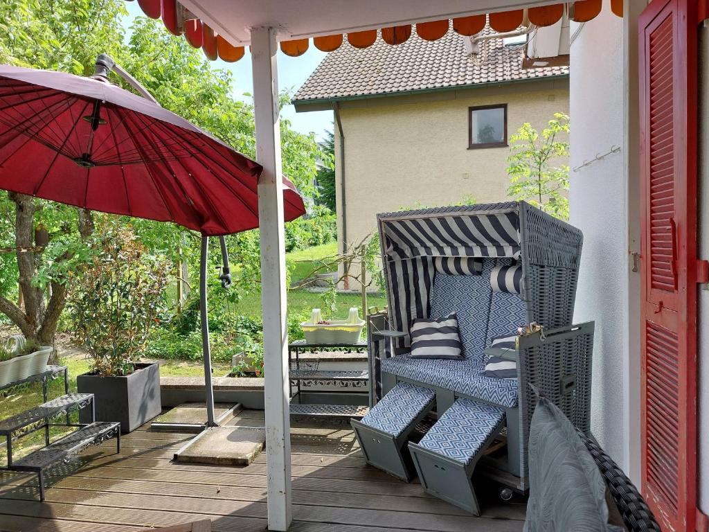 a patio with an umbrella and chairs and a table at Nagoldtal - große Fewo mit Terrasse in Nagold