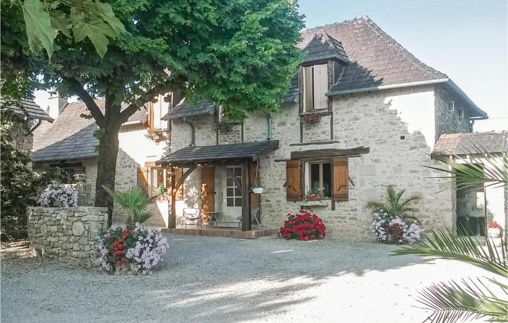 a stone house with flowers in front of it at Stunning Home In Terrasspn-lavilledieu With 3 Bedrooms, Wifi And Outdoor Swimming Pool in Bouillac