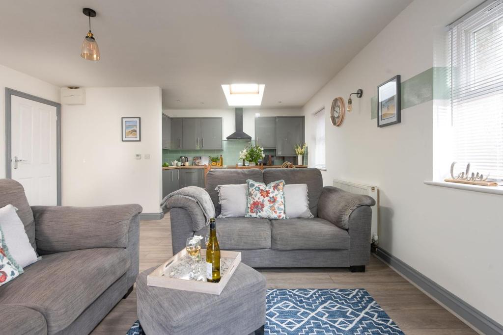 a living room with a couch and a table at Hoopers Lodge, Croft Hooper, Crowlas in Ludgvan