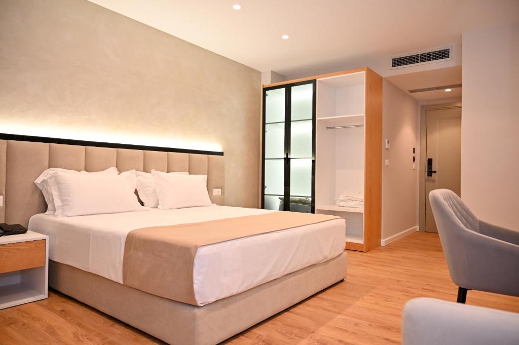 um quarto com uma cama grande e uma cadeira em Hotel Zanzi em Durrës