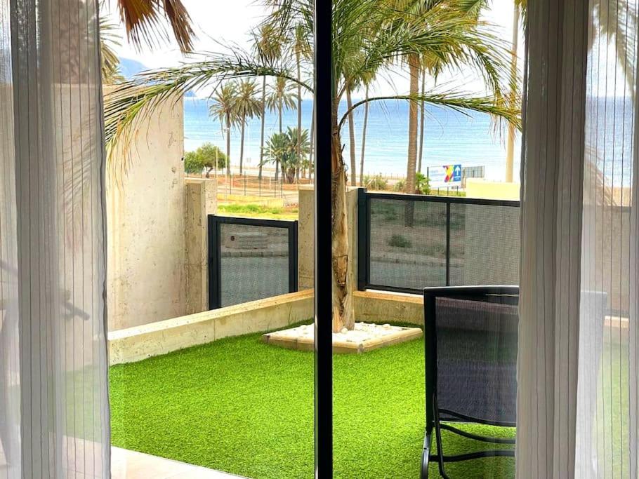 Cette chambre offre une vue sur une cour avec de l'herbe verte. dans l'établissement 2 bedroom infinity beach., à Mazarrón