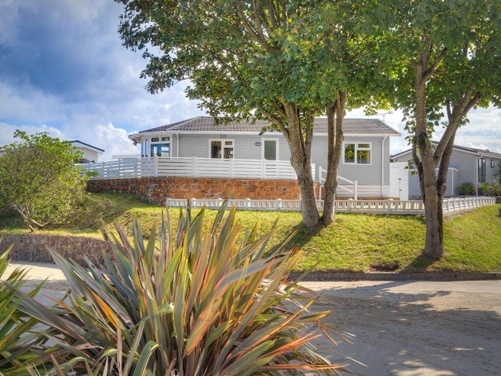 a white house with trees in front of it at E19 The Warren in Pwllheli