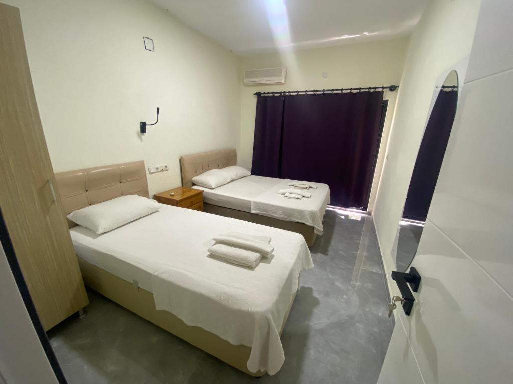 a room with two beds and a window at Beyoglu Pansiyon in Patara