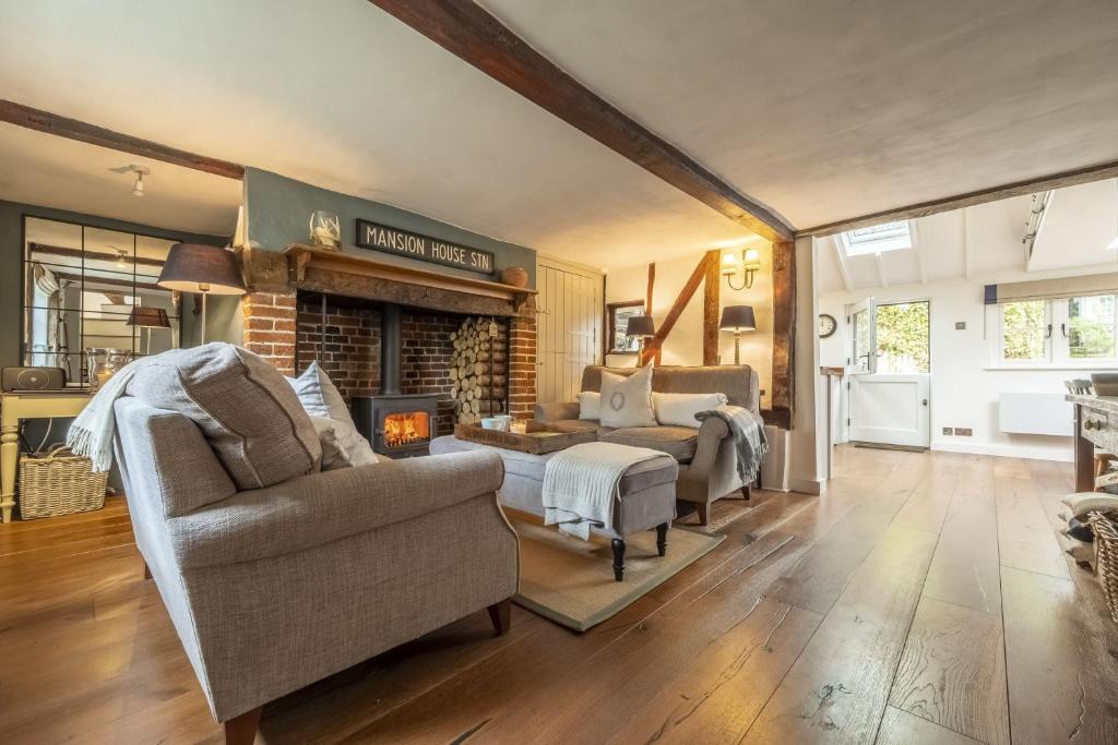 ein Wohnzimmer mit einem Sofa und einem Kamin in der Unterkunft Well Green Cottage in Wenhaston