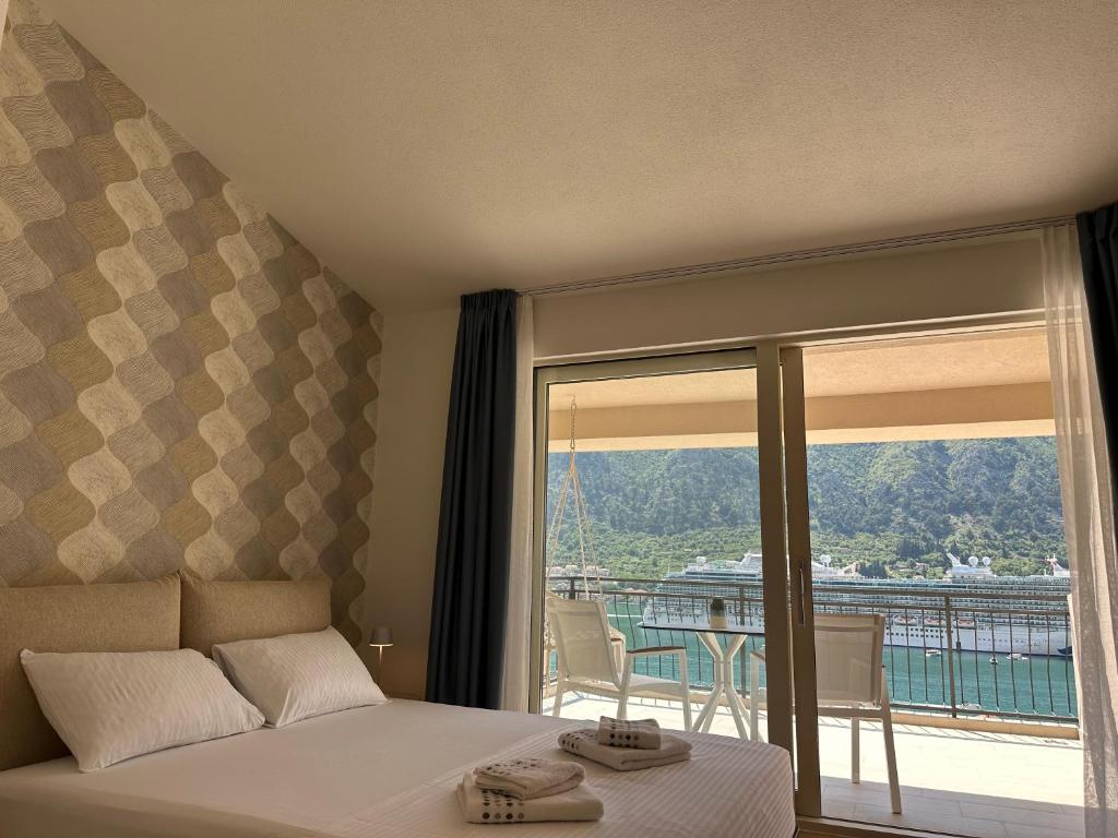 een slaapkamer met een bed en uitzicht op een balkon bij Point of View in Kotor