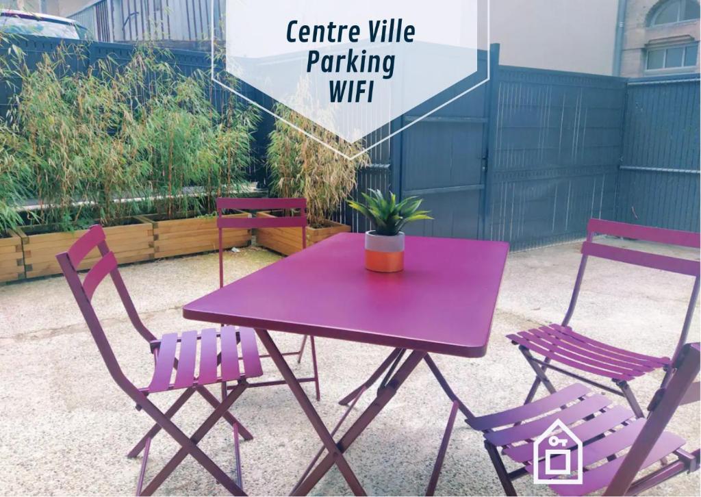 einen lila Tisch und zwei Stühle mit Topfpflanze in der Unterkunft Okera in Mont-de-Marsan