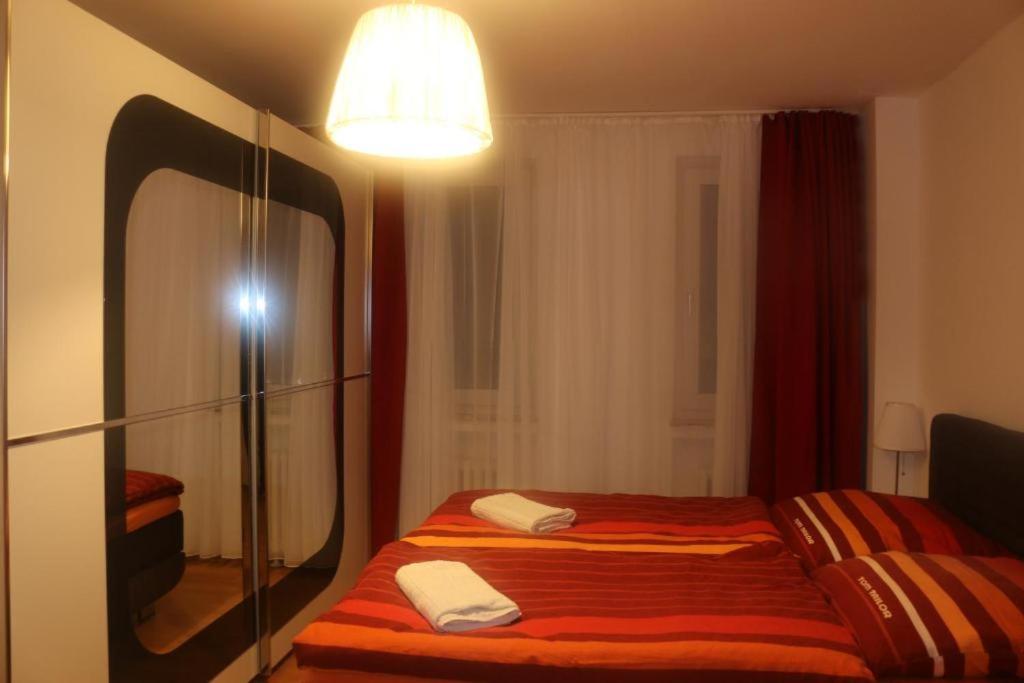 1 dormitorio con 1 cama con espejo grande en Kölner Pension Apartments, en Colonia