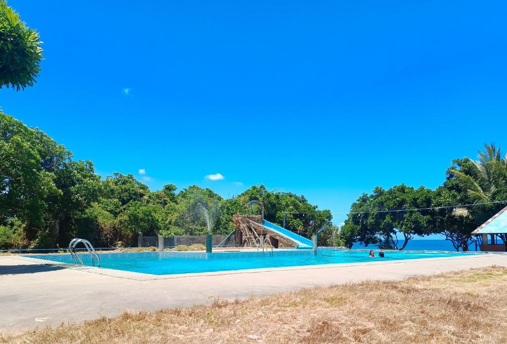 a swimming pool at a park with blue skies at Sunset Beach and Family Resort Gonzaga Cagayan in Bawa