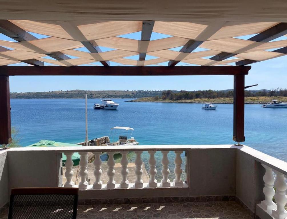 a balcony with a view of a river with boats at Island paradise Lavdara in Sali