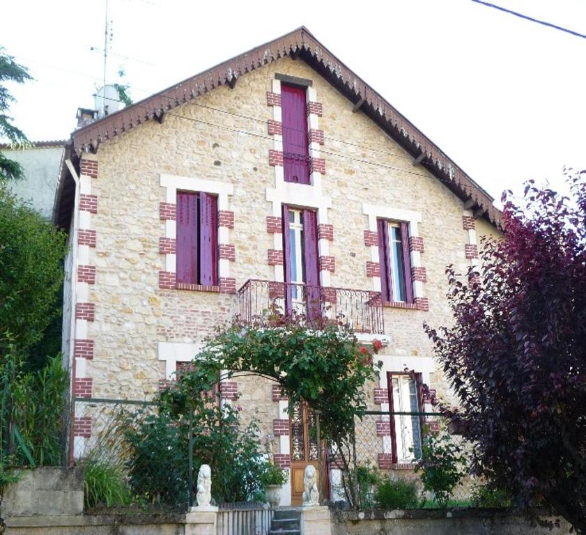 an old brick house with purple shutters on it at BED AND BREAKFAST LES ROSES MULTICOLORES DU 47 in Fumel