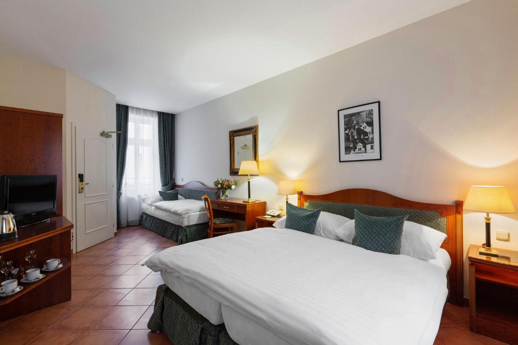 una camera d'albergo con un grande letto e una TV di Hotel Patio Prague a Praga