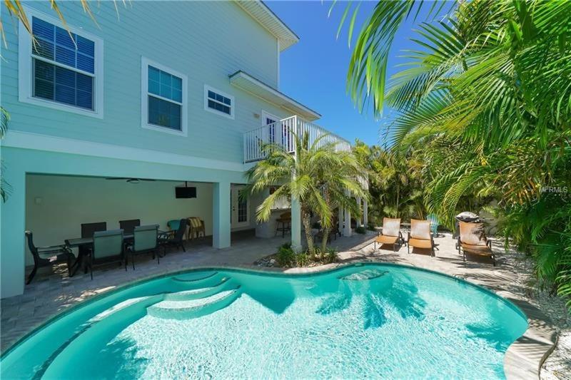 a swimming pool in front of a house at Footprints in the Sand managed by Beach Retreats in Holmes Beach