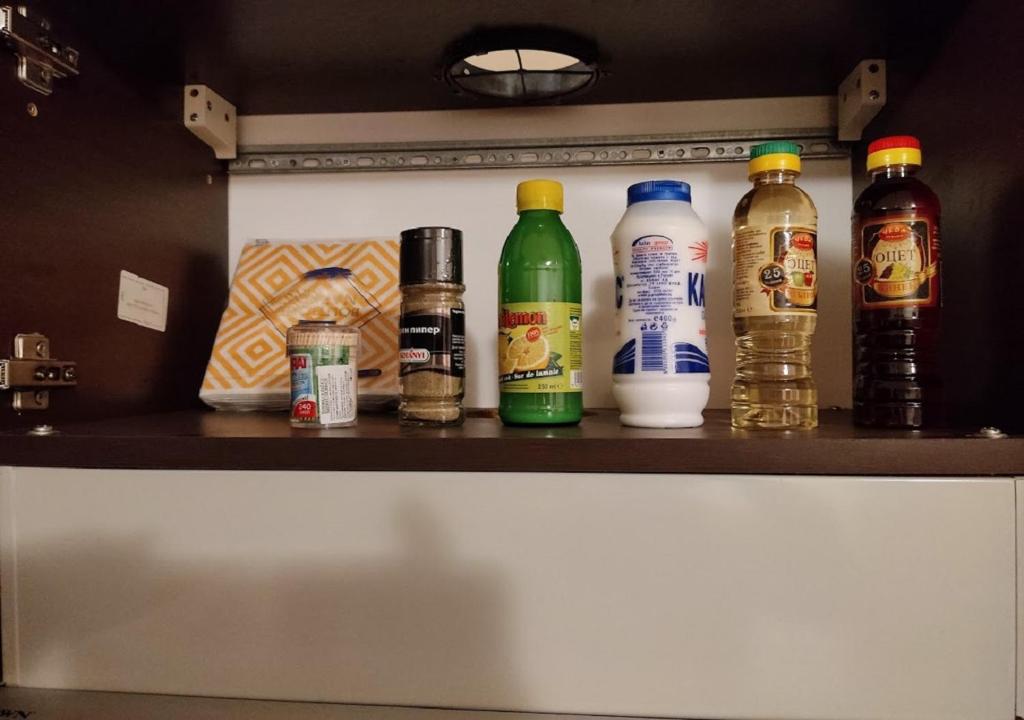 a shelf with different types of bottles on it at Kims One-bed Apart for rent at Sunny Beach Resort in Sunny Beach