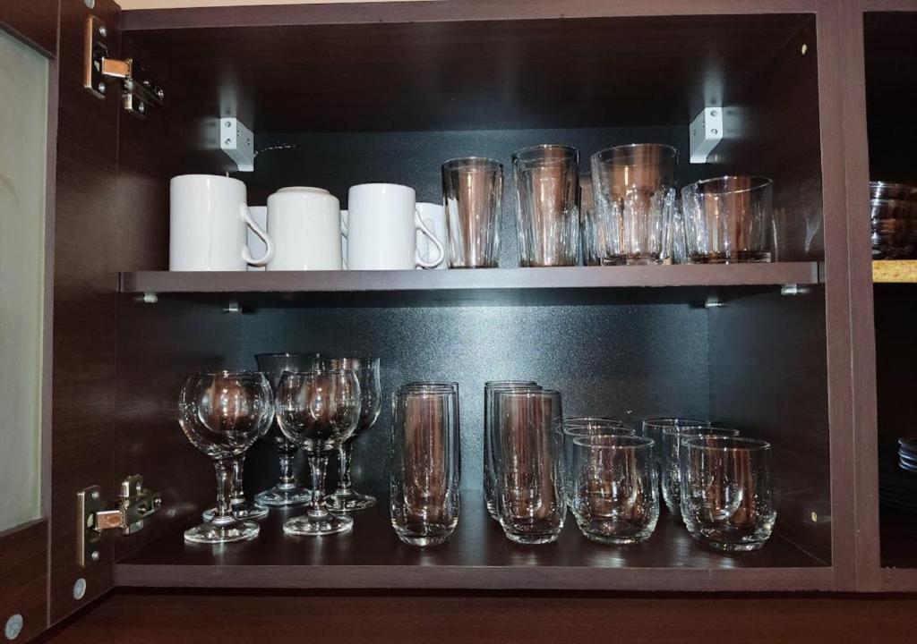 a shelf filled with glasses on top at Kims One-bed Apart for rent at Sunny Beach Resort in Sunny Beach