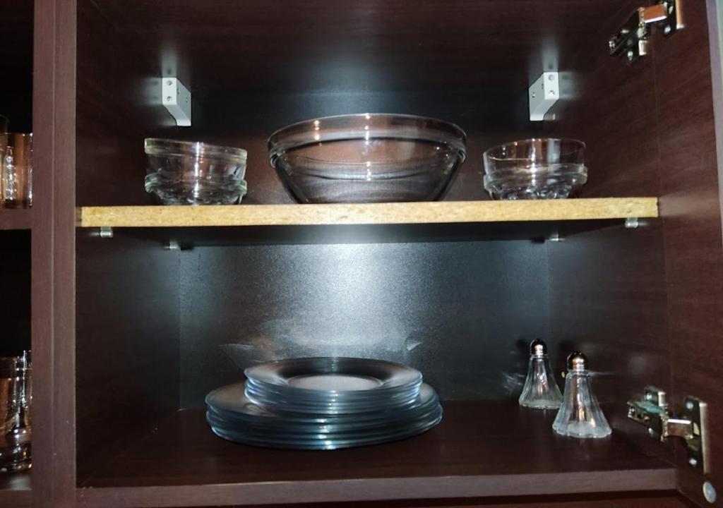a shelf with plates and bowls on it in a kitchen at Kims One-bed Apart for rent at Sunny Beach Resort in Sunny Beach