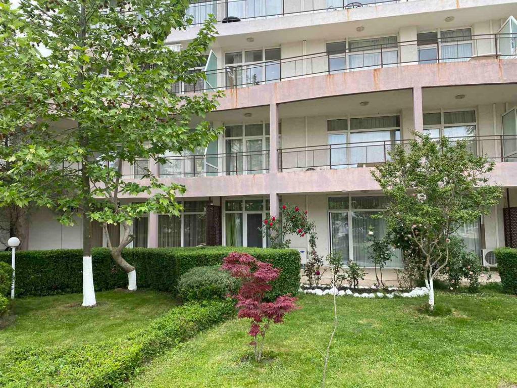 an apartment building with a garden in front of it at Kims One-bed Apart for rent at Sunny Beach Resort in Sunny Beach
