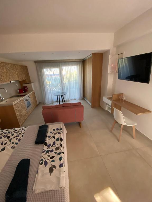 Habitación con cama, sofá y TV. en ANAX SUITE en Pera Gyalos