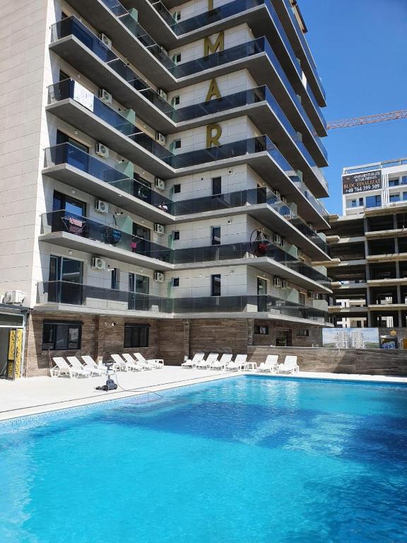 a swimming pool in front of a tall building at Ayan Luxury By Complex Almar in Mamaia Sat/Năvodari