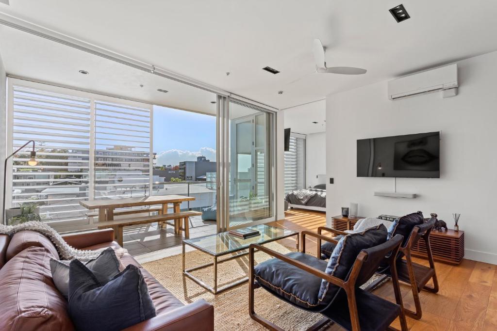 a living room with a couch and a table at Luxury 2 bed2bath penthouse Free secure carpark in Auckland