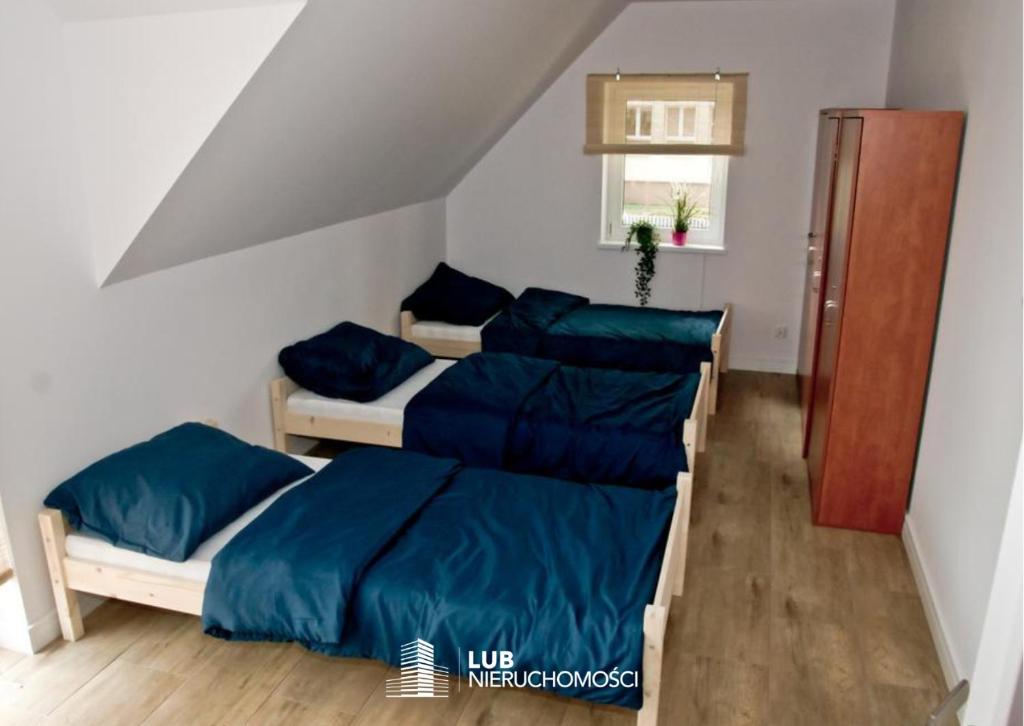 two beds with blue sheets in a room at Noclegi ul. Jędrusiów in Mielec