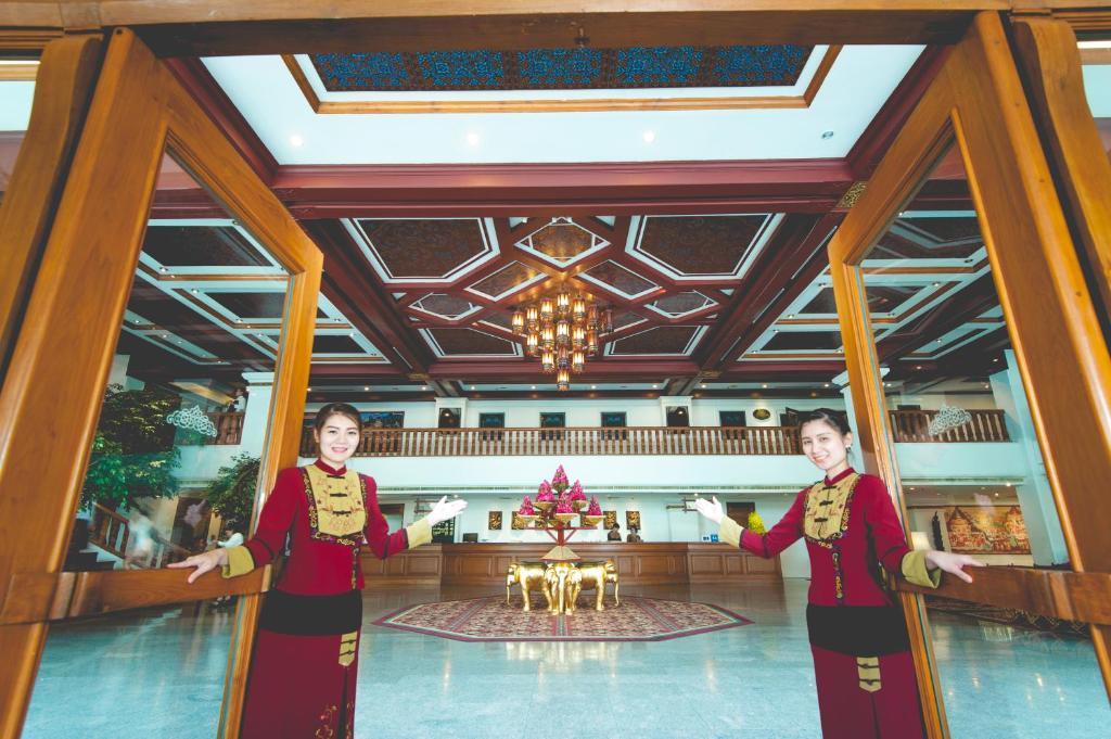 A grand lobby entrance with uniformed staff, ornate ceilings and a central flower display.