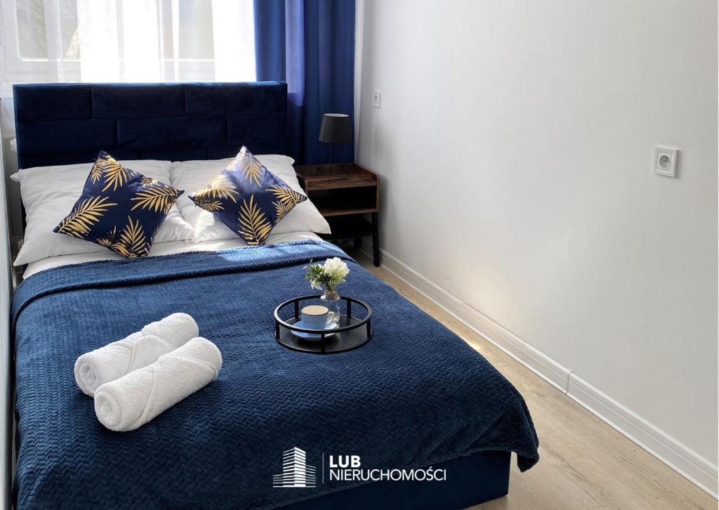 - un lit avec 2 serviettes sur une couverture bleue dans l'établissement Apartament Midnight Blue, à Mielec