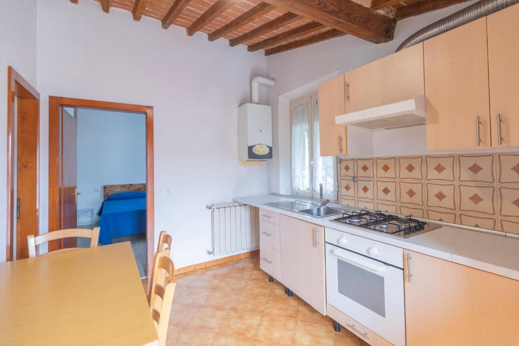a kitchen with white cabinets and a table and a counter top at Appartamento Per Due by HelloElba in Portoferraio