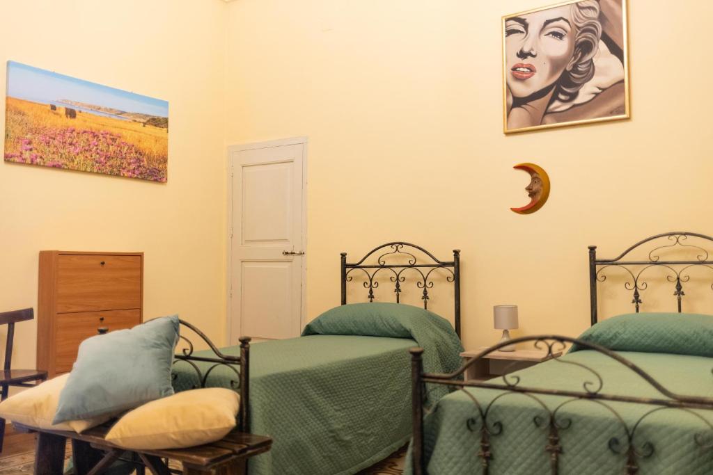um quarto com duas camas e um quadro na parede em casa vacanza Noctua em Galatina