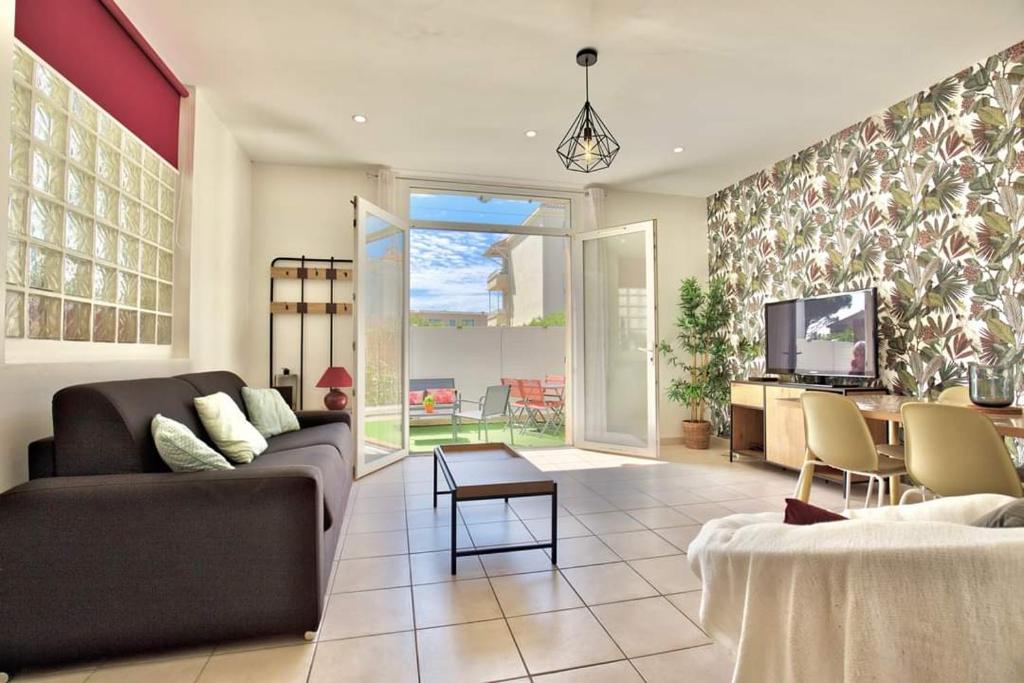 Una sala de estar con un sofá y un televisor. en Residence Provence plage, en La Ciotat